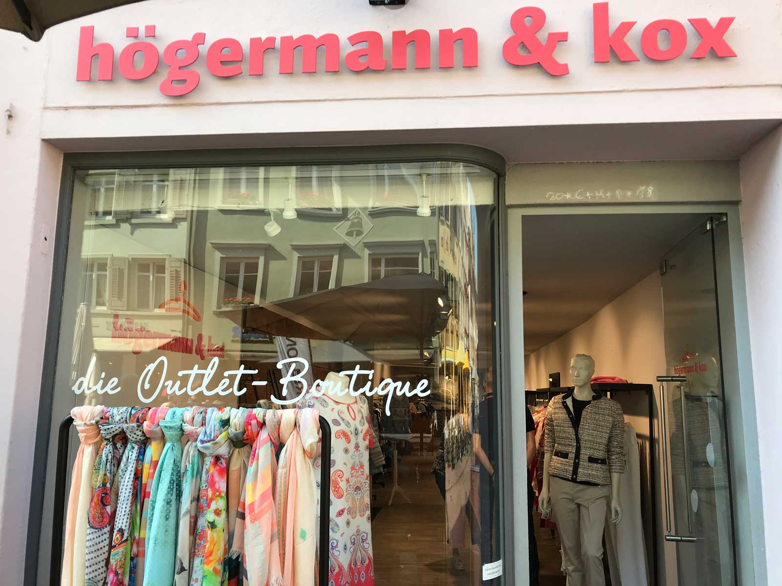Schaufenster der Boutique "högermann & kox" mit farbenfrohen Schals und einem Schaufensterpuppen-Outfit.