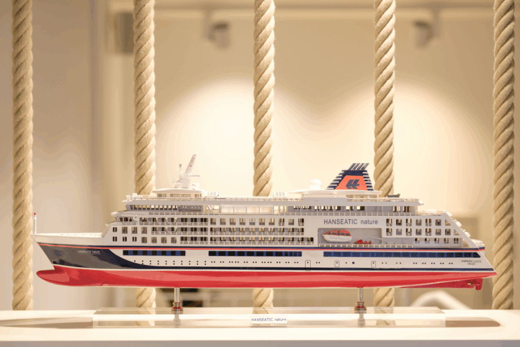 Miniaturmodell eines Kreuzfahrtschiffs namens "HANSEATIC nature" vor einem neutralen Hintergrund.