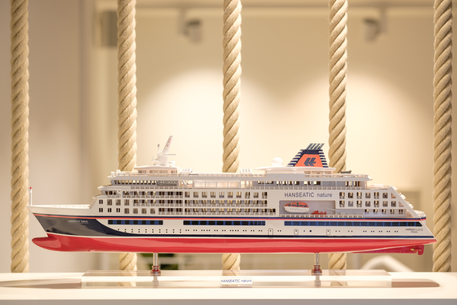 Miniaturmodell eines Kreuzfahrtschiffs namens "HANSEATIC nature" vor einem neutralen Hintergrund.