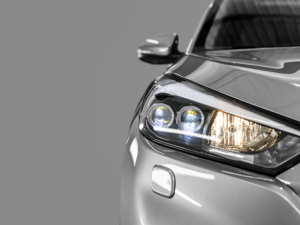 Nahaufnahme eines silbernen Autoscheinwerfers mit einem modernen, eleganten Design.